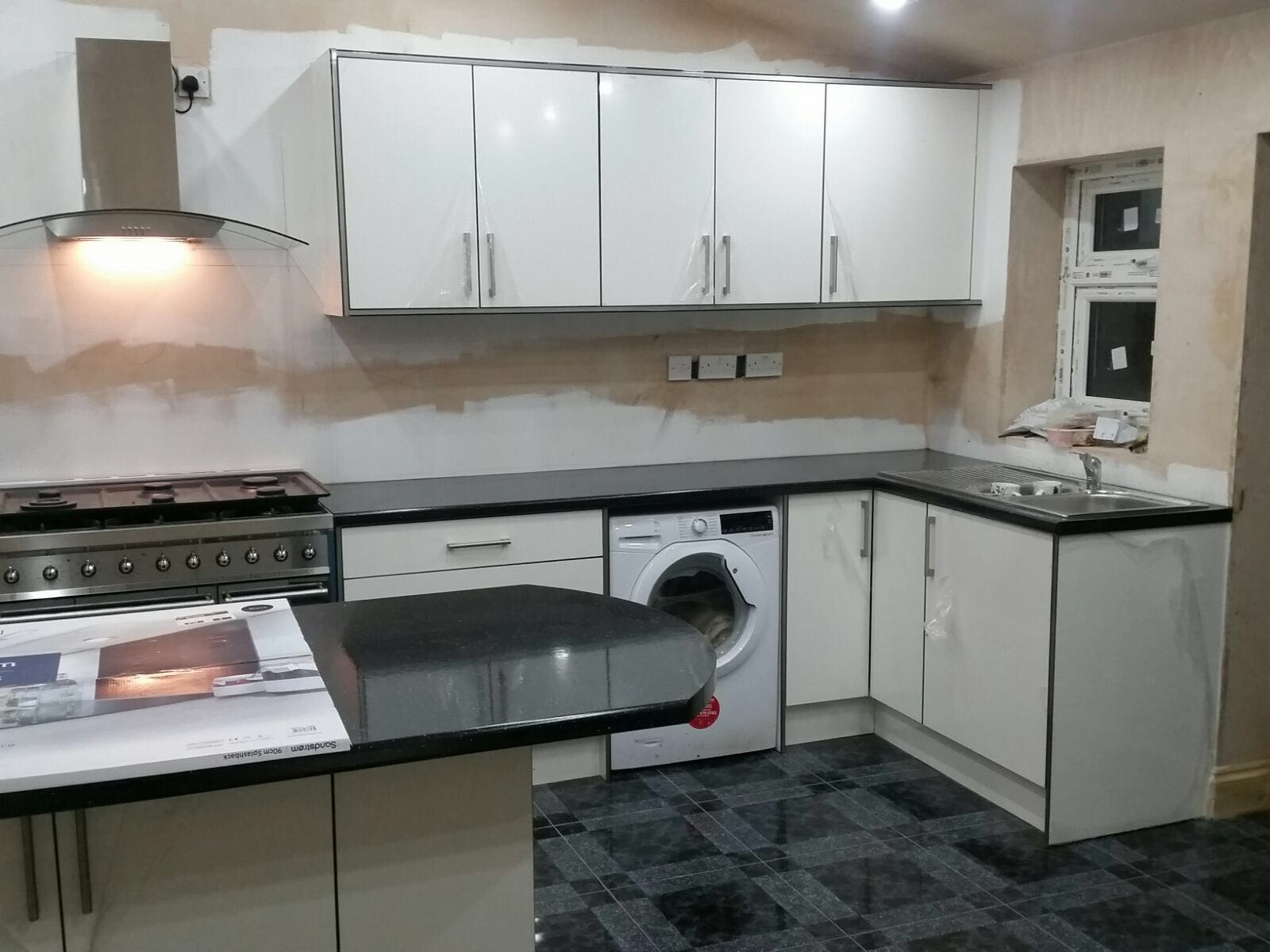 Fitted kitchen installation in progress with gloss units